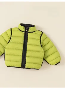 Detail view of lime green reversible puffer jacket with horizontal quilting and black zippers