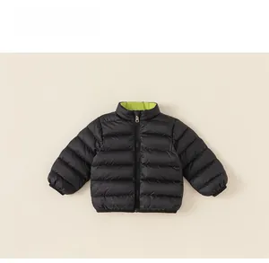 Detail of reversible kids down jacket featuring black shell and neon green inner lining