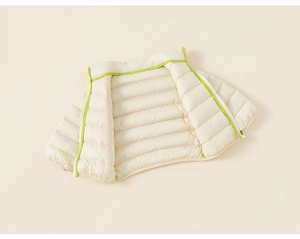 Detail of light beige kids down vest showing neon green piping and horizontal quilting