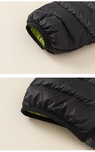 Detail of lightweight puffer jacket showing black quilted fabric and neon green lining