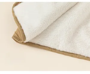 Detail of winter jacket with thick white plush fleece lining and coffee brown outer fabric