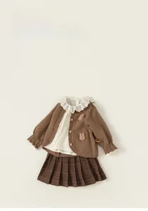 Detail of child knit cardigan with plush bear decor and lace collar floral accents