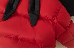 Close-up of red down jacket with horizontal quilting and black bunny ear neck ties