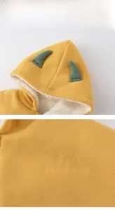 Détail de la cape dinosaure jaune pour bébé avec doublure polaire et broderie élégante