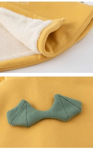 Vue détaillée d'un poncho tricoté jaune avec une doublure douce en fausse fourrure