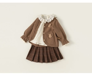 Detail of girls knit cardigan with bunny decor, lace shirt and plaid pleated skirt set