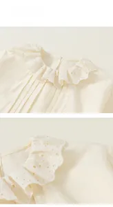 Detailed view of girl's cream cotton shirt featuring lace collar and pleated front textures