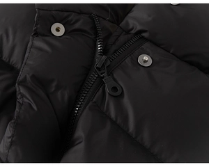 Detailed close-up of heavy-duty black resin zipper and metal snap buttons on down jacket