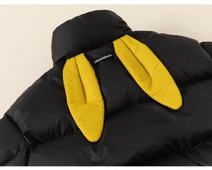 Detail view of children's black puffer jacket with yellow bunny ears on the collar