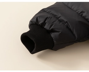 Detailed view of black down jacket sleeve with ribbed cuffs and quilted nylon fabric