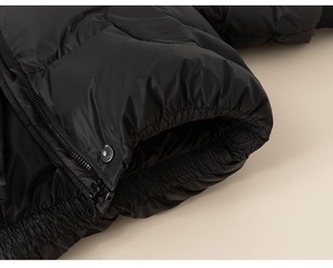 Close-up of black quilted puffer jacket featuring elastic cuffs and metal zipper details