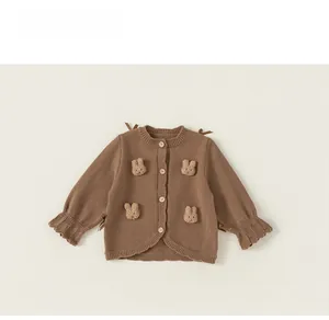 Detail of child knit cardigan with plush bunny accents and natural wooden buttons