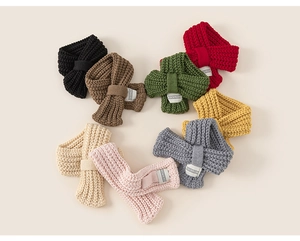 Dettaglio di sciarpe in maglia per bambini in otto colori con etichette del marchio tessute