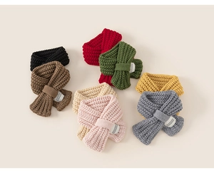 Dettaglio di sciarpe in maglia per bambini con design a incrocio e texture morbida