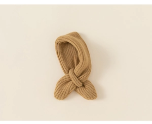 Detail of warm brown knit scarf showing thick ribbed texture and crossover design