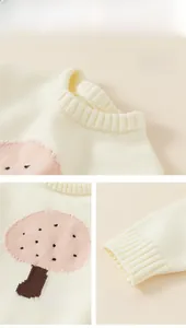 Close-up of pink mushroom jacquard pattern and ribbed cuffs on cream knit sweater