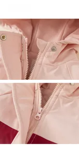 Detailed macro view of the zipper and metal snap button on this pink hooded jacket