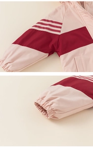 Detail of color-block windbreaker jacket featuring elastic cuffs and pink striped sleeves