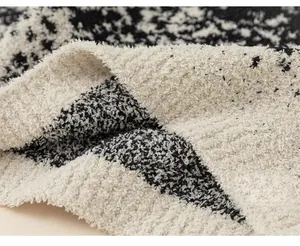 Macro detail of the thick and soft black and white speckled fleece texture on kids sweater