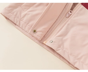 Detail view of pink windbreaker jacket featuring matching zipper and metal snap buttons
