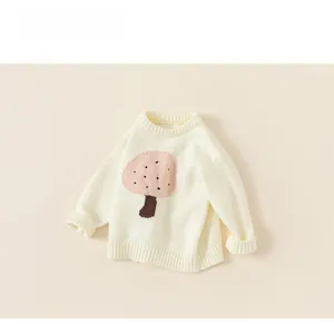 Detail shot of a cream knit sweater for girls featuring a cute pink mushroom pattern