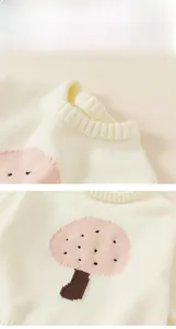 Close-up of ribbed crewneck and pink mushroom embroidery on white knit sweater