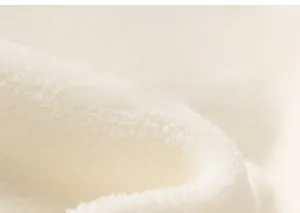 Close-up of soft white sherpa fleece fabric texture showing plush winter insulation