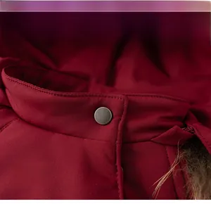 Close-up of winter coat collar showing neat stitching and metal snap button detail