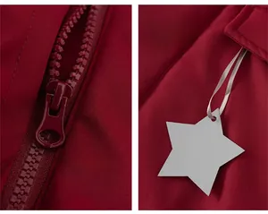 Detail of burgundy kid's jacket featuring a smooth resin zipper and star-shaped tag