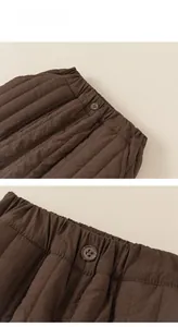Detailed view of quilted cotton pants with elastic waistband and vintage button texture