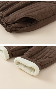 Detail of brown quilted kids trousers with thick fleece lining and elastic waistband