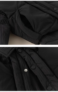 Nahaufnahme der Winterjacke mit Steppstoff und einem mattierten Knopf mit DESIGN-Logo