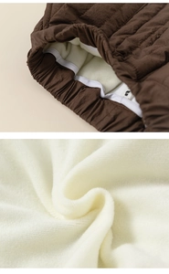 Detailed close-up of kids' winter trousers with warm fleece lining and quilted brown fabric