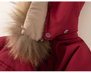 Detail of burgundy winter coat with plush fur collar and clear resin buttons