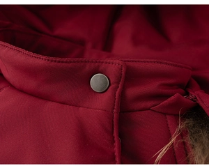 Macro view of burgundy winter coat with vintage metal button and faux fur collar detail