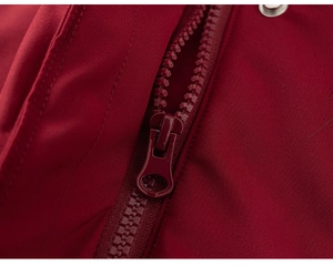 Macro shot of durable resin zipper and metal buckle on red hooded winter jacket
