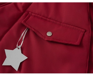 Close-up of red hooded coat featuring silver metal snap buttons and star tag detail