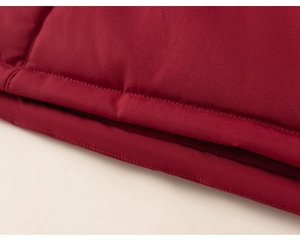 Detailed macro view of the premium red winter coat fabric with reinforced double stitching