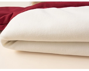 Detailed macro view of the thick white fleece lining and red woven fabric of the winter coat
