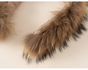 Detailed view of fluffy brown fur collar with black tips and khaki quilted lining