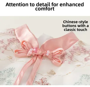 Detail of traditional Chinese frog fastener with pearl bead and floral embroidery on satin
