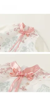 Detail of Chinese style dress featuring floral embroidery, pink bow, and pearl collar