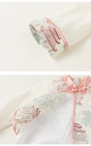 Detail of Chinese style embroidery and pink frog button on white girl's traditional top