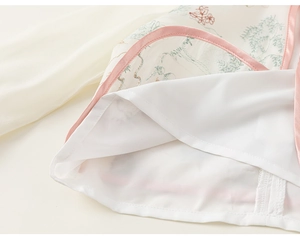Close-up of floral embroidery and satin piping on the traditional Chinese kids' dress