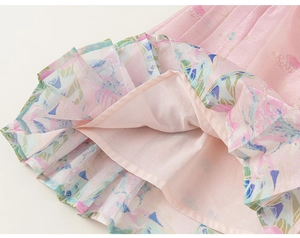 Detail of girls' pleated skirt featuring pearlescent fabric with watercolor floral patterns