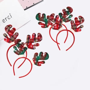 Detail of four Christmas reindeer headbands with red plaid patterns and white snowflake motifs