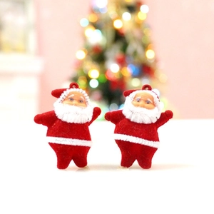 Close-up of two mini Santa Claus figurines with red flocking for Christmas tree decor