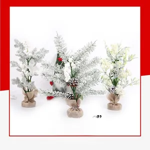 Close-up of three mini flocked Christmas trees with pine cones and burlap bases