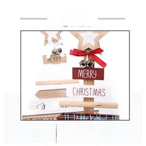 Close-up of wooden Christmas tree tabletop decor with festive text and mini white bells