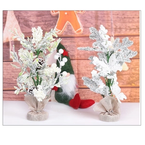 Detail of mini snow-flocked Christmas trees with pine cones and rustic burlap-wrapped bases